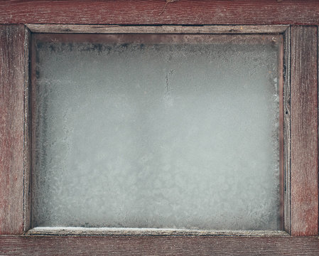 frosty patterns on a window with a wooden frame