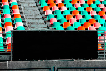Black wall for text with space. Free brand wall. Background with Empty seat chairs at stadium