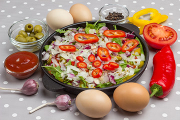 Set of vegetables for healthy eating, yellow and red peppers, olives, tomatoes, onions, garlic. Sliced vegetables in pan.