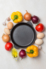 Frying pan. A set of vegetables for a healthy diet, yellow and red peppers, tomatoes, onions, garlic.  .