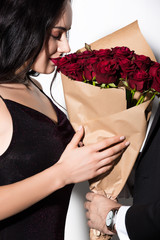 beautiful young woman holding bouquet of red roses on valentines day on white