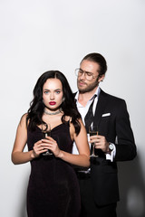 couple in suit and dress holding champagne glasses for valentines day on white