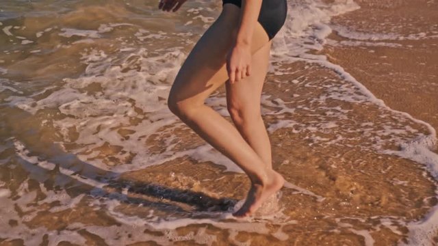 Back View Of A Sexy Young Woman Walking Along The Shore During Sunset in Australia - Slow motion