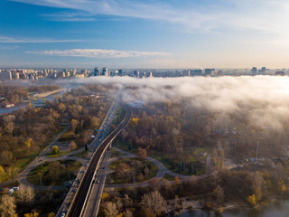 Aerial drone view. Light fog rises from the Dnieper River and covers Kiev.