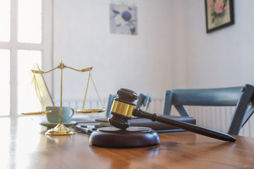 The mallet and brass scales are placed on the table in the lawyer's office for decorative purposes and are a symbol of justice in court decisions.