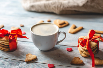 Cup of coffee and a message from a sweet cookie in the form of the word love. Romantic Valentine's day gift