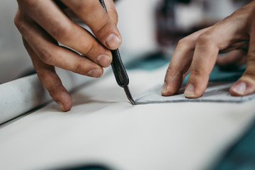 Close up shot of old shoemaker in his store. Traditional way of shoe making process.
