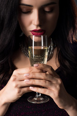 young woman with closed eyes holding glass of champagne, isolated on grey