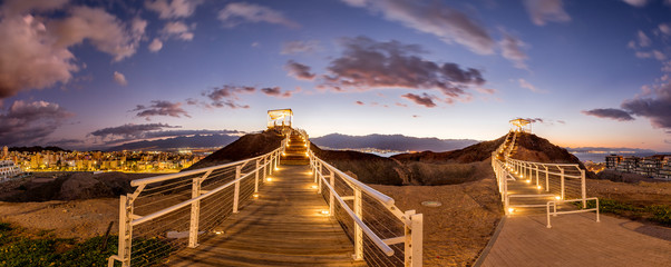 Night at a top of the stone hill with illuminated pergola and walkway, public park in vicinity of...