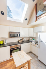 Modern, bright, clean, kitchen interior with stainless steel appliances in a luxury house.