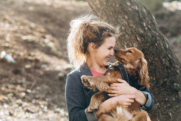 Candid portrait of attractive young emotional woman with her beautiful brown english cocker spaniel...