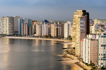 Obraz premium Tall buildings near to the beach of a coastal city during the day. Paulista coast, Sao Vicente city - SP Brazil.