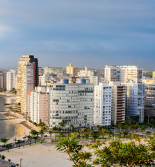 Fototapeta na wymiar Coastal city with many tall buildings near to the beach. Aerial view of Sao Vicente city, SP Brazil. Paulista coast of Brazil. 