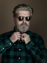 Man face close up. Handsome bearded man posing on grey background. Man face. Portrait of handsome man against dark wall.