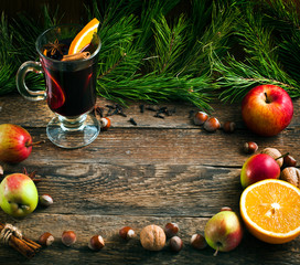 Christmas hot mulled wine with spices and fruits on a old wooden background. Autumn background,...