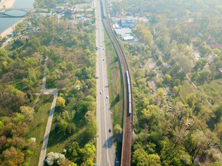 Aerial drone view. The train of the Kiev subway passes through the park.