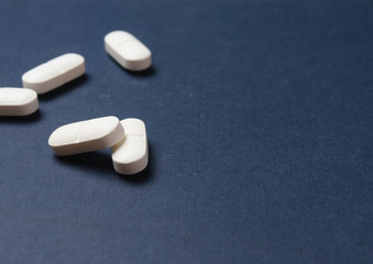 Medical pills on a blue background closeup, copy space