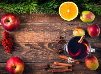 Christmas hot mulled wine with spices and fruits on a old wooden background. Autumn background,...