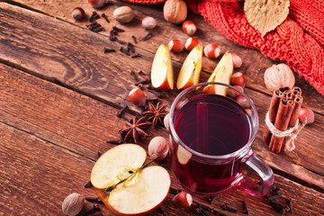 Christmas hot mulled wine with spices and fruits on a old wooden background. Autumn background, Christmas background. Text space.
