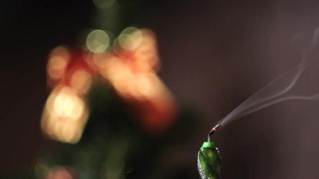 Close-up of Christmas extinct candle against the blurred Christmas tree silhouette with lights and decorations. Concept. Christmas mood