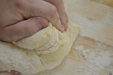 cook kneads pizza dough with his hands