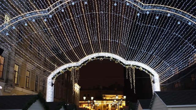 View from the bottom on the beautiful Christmas decorations on the street, white garland of lights and street lights. Concept. Christmas mood