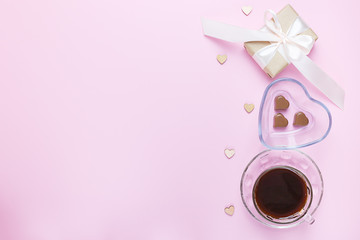 Banner of Valentine's Day. A Cup of coffee, a gift box and a heart-shaped chocolate on a pink background.