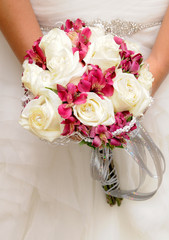 Romántico ramo de rosas blancas y lirios de color rosa en las manos de una novia