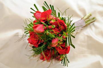 Romántico ramo de rosas rojas sobre el vestido de una novia