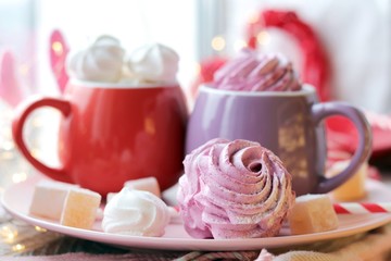 Two cups of coffee with meringues and marshmallows, Turkish delight on a plate, hearts, illumination, against the background of a window, homeliness, Valentine's day, romantic greeting, happy birthday