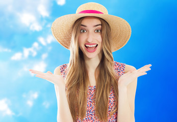 Happy woman in summer hat posing on blue sky background.