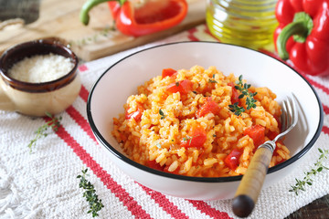 Italian food. Plate of red bell pepper risotto, olive oil and parmesan cheese