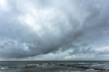 landscape of wide sandy beach by the cold sea in cloudy weather