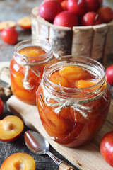 Autumn sweet. Homemade red plums jam in two jars and fruits