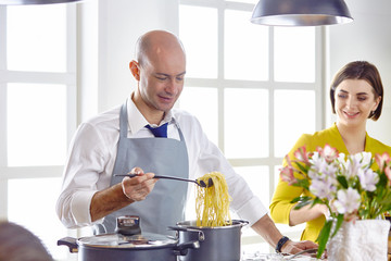 Smiling young couple cooking food in the kitchen