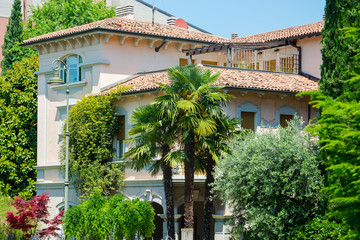 Fototapeta na wymiar Building in the palm tree garden in the center of Verona, Italy