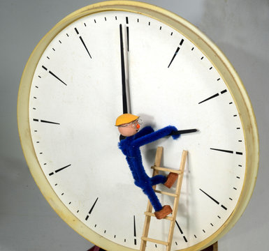 Clockman Adjusting A Clock To Or Back From Daylight Saving Time (DST)