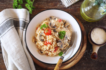 Italian cuisine. Plate of mushroom risotto with cherry tomatoes and parmesan cheese