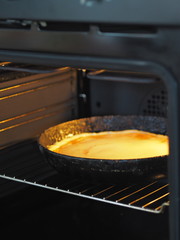 Round homemade pie with pumpkin, chopped walnuts, topped with beaten eggs with sugar in a pan in the oven for baking. Homemade baking.