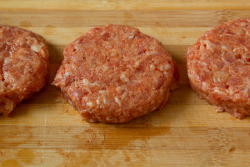 Raw meatballs on a chopping board with ingredients