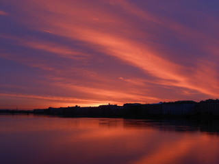 Fototapeta na wymiar Bright colorful sunrise or sunset in Saint-Petersburg. Landscape. Neva river and sea