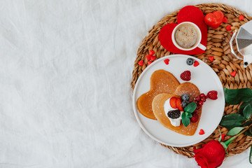 Flat Lay Romantic Breakfast in Bed, Heart shape Pancakes and Coffee on White Bed Sheet