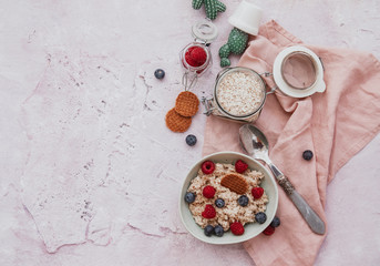 Flat Lay Oatmeal with berries in bowl for breakfast on blue background. Healthy food concept. Top view
