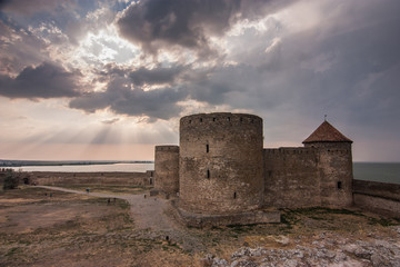Fototapeta na wymiar Akkerman fortress over dramatic sky in sunset sunrays. Bilhorod-Dnistrovskyi, Odesa oblast, Ukraine