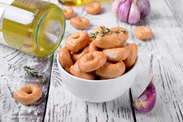 Italian snack Tarallini with herbs and garlic in a white ceramic bowl