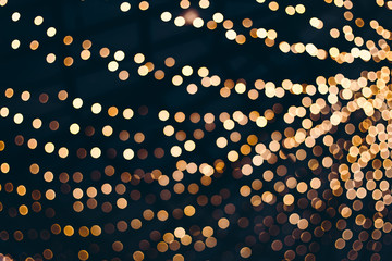 Decorative outdoor string lights at night time, Defocused Background, night city life backdrop, party time with Yellow bokeh balls - obrazy, fototapety, plakaty