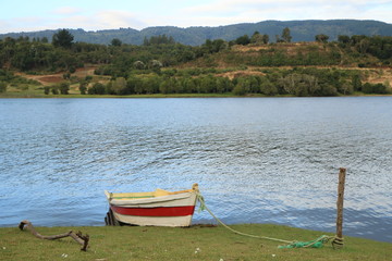 bote en lago con cerros de fondo