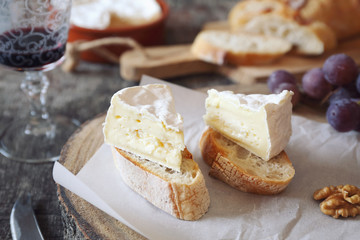 French dessert. Two slices of Camembert cheese on bread and glass of red wine