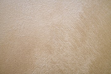 Light beige peach pearl plaster background with smears in the direction from top to left to right.