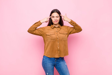 young pretty woman with a serious and concentrated look, brainstorming and thinking about a...
